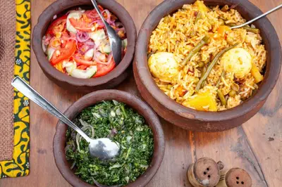 four bowls of food on a wooden table at Karatu Tented Lodge in Karatu