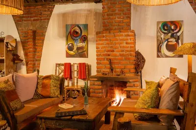 a living room with a couch and a fireplace at Karatu Tented Lodge in Karatu