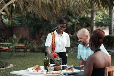 a man standing in front of a table with food at Chanya by Ardhi Africa in Moshi