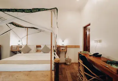 a bedroom with a canopy bed and a wooden desk at Chanya by Ardhi Africa in Moshi