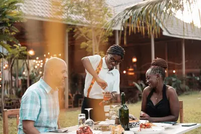 a woman serving a man and woman at a table at Chanya by Ardhi Africa in Moshi