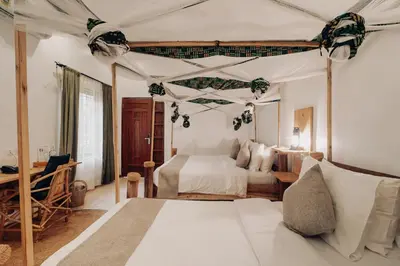 a bedroom with a bed and a bed and a desk at Chanya by Ardhi Africa in Moshi