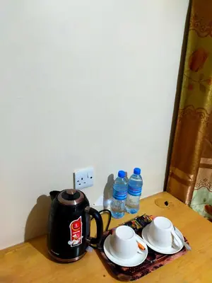 a tea kettle and plates on a table with water bottles at Kilimanjaro Star Hotel in Moshi