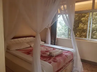 a bedroom with a canopy bed with a window at Kilimanjaro Star Hotel in Moshi