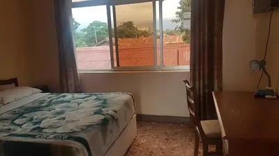a bedroom with a bed and a window and a desk at Kilimanjaro Star Hotel in Moshi
