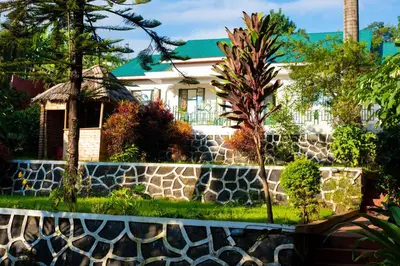a house with a retaining wall and a stone fence at Mambo Hideaway in Arusha