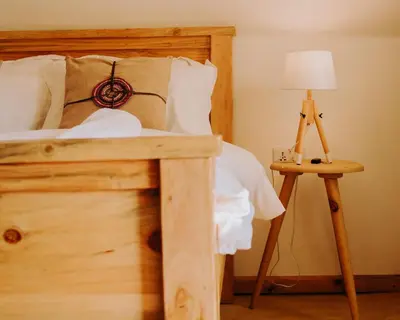a bedroom with a bed and a table with a lamp at Mambo Hideaway in Arusha