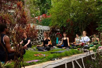 a group of people sitting in the grass in meditation at Mambo Hideaway in Arusha