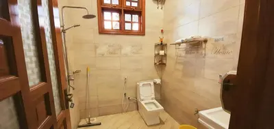 a bathroom with a toilet and a shower at Cape of Goodhope Vacation Home in Arusha