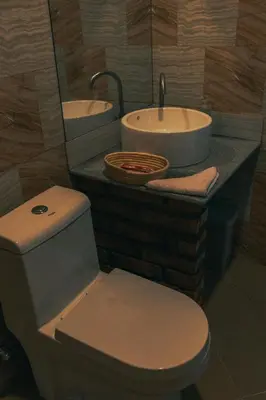 a bathroom with a toilet and a sink at Kutoka Lodge in Arusha