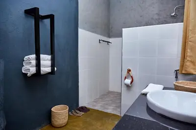 a bathroom with a sink and a shower with towels at Kutoka Lodge in Arusha