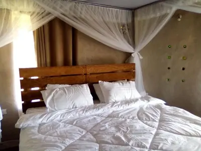 a bedroom with a white bed with a canopy at Kutoka Lodge in Arusha