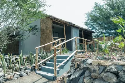 a house with stairs in front of a building at Kutoka Lodge in Arusha