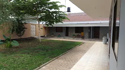 a house with a walkway in front of a yard at Kilimanjaro Country House in Moshi
