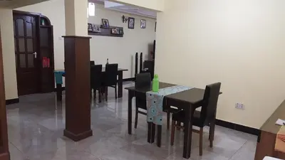 a dining room with black tables and black chairs at Kilimanjaro Country House in Moshi