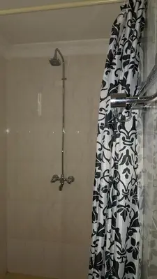 a shower with a black and white shower curtain at Kilimanjaro Country House in Moshi