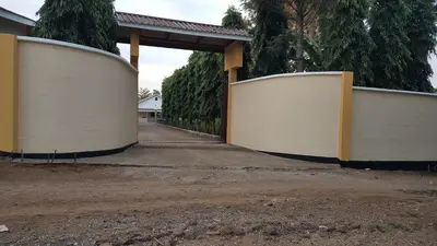 a pair of white gates in front of a driveway at Kilimanjaro Country House in Moshi