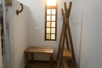 a room with a wooden stool and a window at Haradali's Home in Arusha