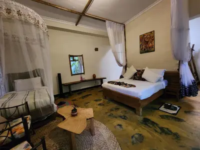 a bedroom with a bed and a table in a room at Haradali's Home in Arusha