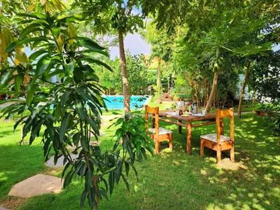 a table and chairs in a yard with a pool at Haradali's Home in Arusha