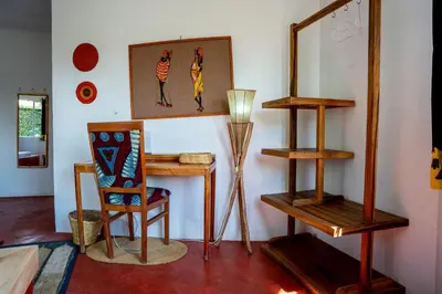 a room with a chair and a desk and a lamp at Dan Stam Hotel in Arusha