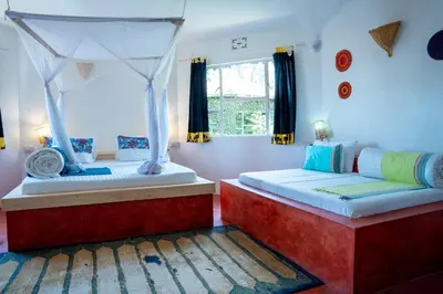 a bedroom with two beds and a window at Dan Stam Hotel in Arusha