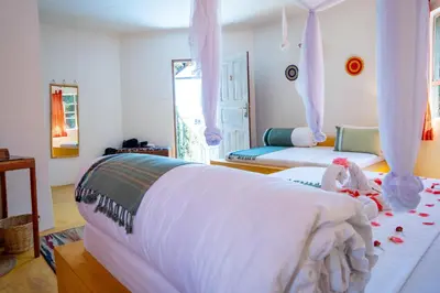 a bedroom with a bed with a white blanket at Dan Stam Hotel in Arusha