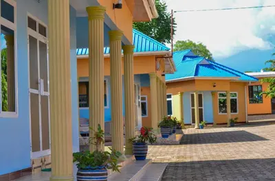 a row of houses with columns and plants in front at New Favour Lodge in Arusha
