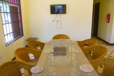 a conference room with a table with chairs and a television at New Favour Lodge in Arusha