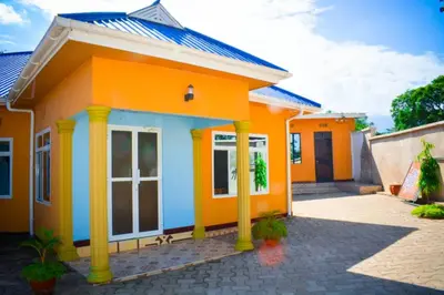a small house with an orange and blue at New Favour Lodge in Arusha