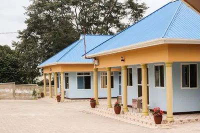 a blue and yellow house with a blue roof at New Favour Lodge in Arusha