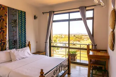 a bedroom with a bed and a large window at Lilac Elevate Inn in Karatu