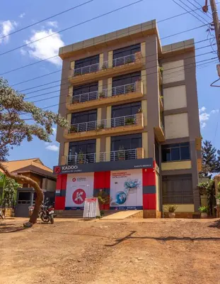 a tall building with a sign in front of it at Lilac Elevate Inn in Karatu