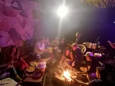 a group of people sitting around a fire at First Point Arusha Hostel in Arusha