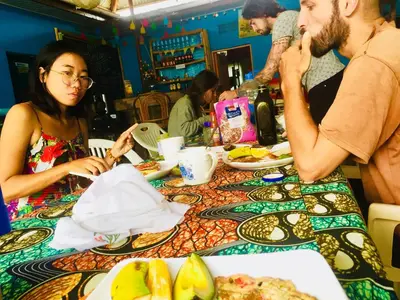 a group of people sitting at a table eating food at First Point Arusha Hostel in Arusha