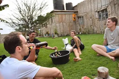 a group of people sitting on the grass with a dog at First Point Arusha Hostel in Arusha