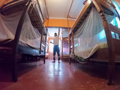 a woman standing in a tent in a room at First Point Arusha Hostel in Arusha