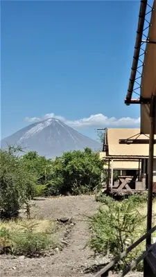 a mountain in the distance with a house in the foreground at Africa Safari Lake Natron in Mtowabaga