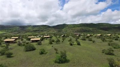 an aerial view of a field with houses and trees at Africa Safari Lake Natron in Mtowabaga