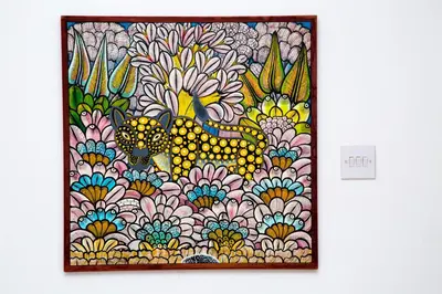 a painting of a cat in flowers on a wall at Lavender Coffee Farm House in Arusha