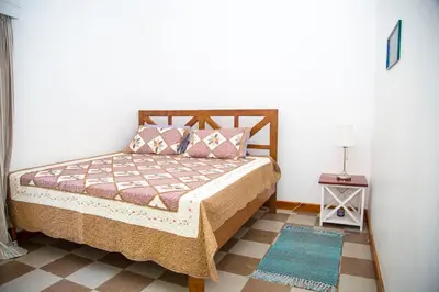 a bedroom with a bed and a tiled floor at Lavender Coffee Farm House in Arusha