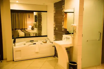 a bathroom with a sink and a tub and a mirror at SG Premium Resort in Arusha