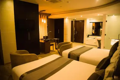 a hotel room with two beds and a television at SG Premium Resort in Arusha