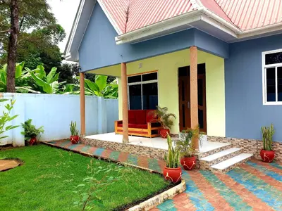 a blue and yellow house with a red couch at Turaco Homestay in Arusha