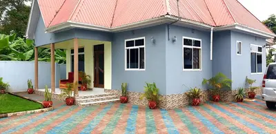 a blue house with a red roof at Turaco Homestay in Arusha