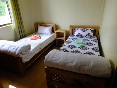 a small room with two beds and a window at Enjivai Hostel in Arusha