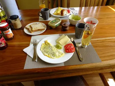 a table with plates of breakfast food on it at Enjivai Hostel in Arusha