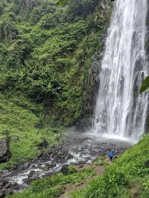 a waterfall on the side of a mountain at Backyard Eco Bungalows Moshi in Moshi