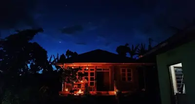 a house with a fire on the roof at night at Mai Kilimanjaro Home Stay in Marangu