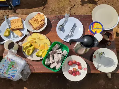 a wooden table with plates of food on it at Mai Kilimanjaro Home Stay in Marangu
